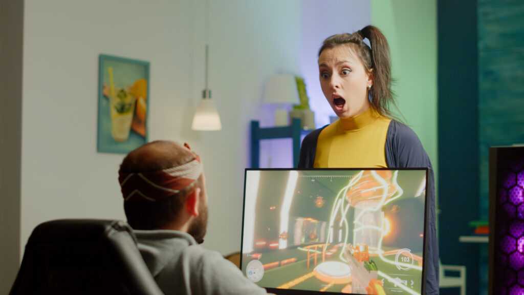 nervous woman screaming husband while he is playing space shooter videogame rgb powerful computer streaming online competition pro cyber with headset performing virtual tournament